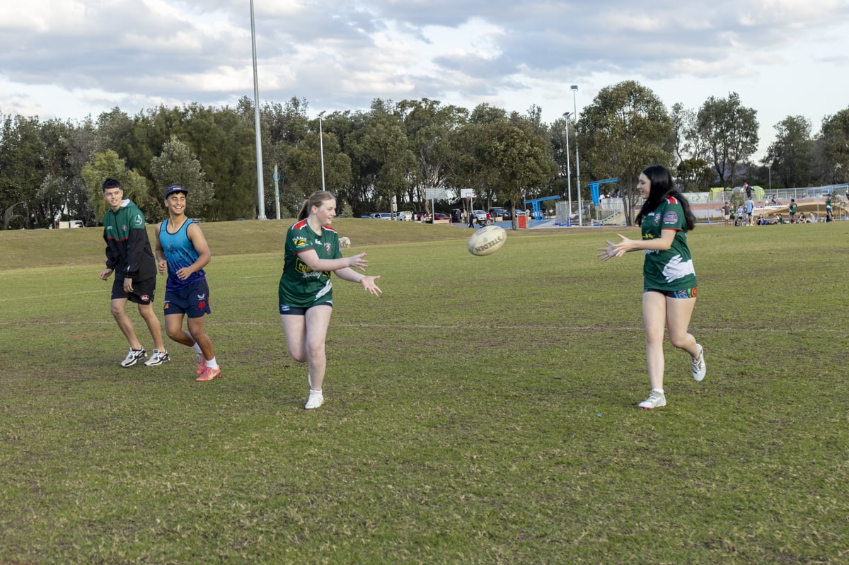 girls passing rugby ball with boys alongside