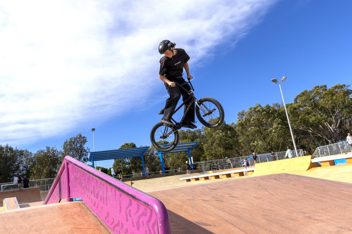 skate park with teen boy in air on BMX bike