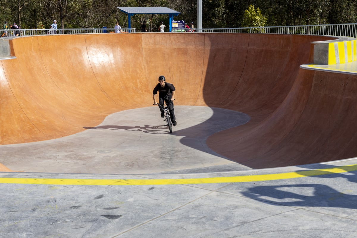 skate park deep bowl with boy on bike 